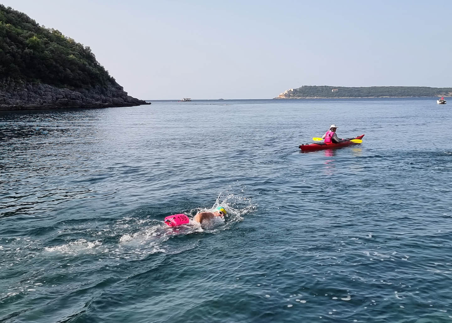 A person swimming front crawl in the sea, viewed from the side.
